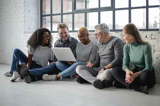 Group of five look at laptop