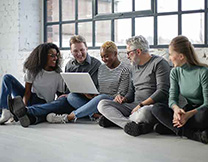 Group of five look at laptop